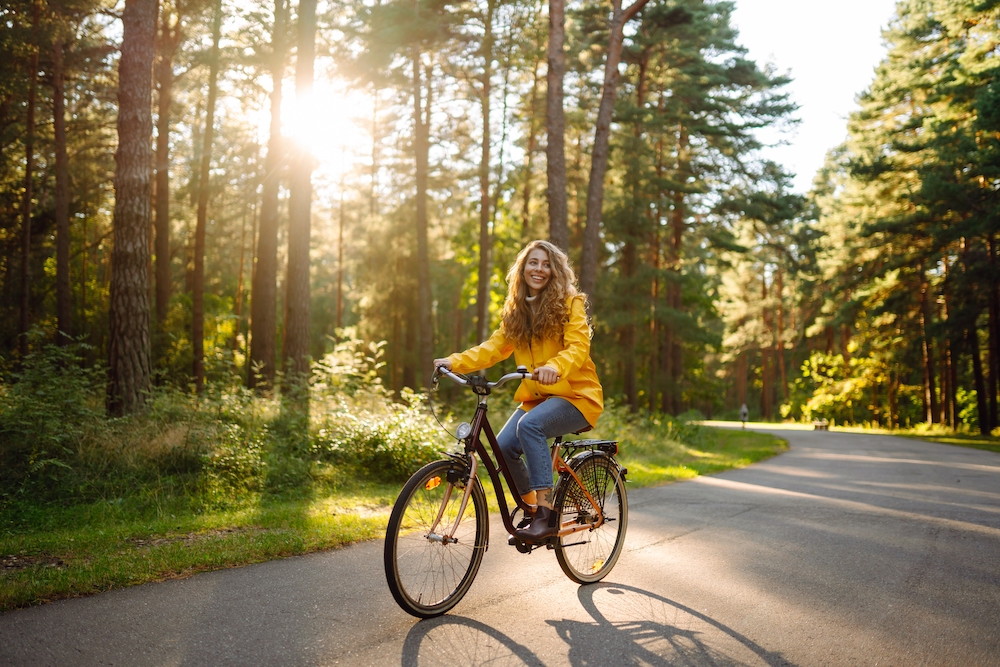 A woman rides a bike in the park.